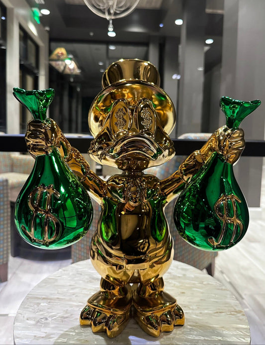 Gold and green decorative figure with dollar signs on a marble surface