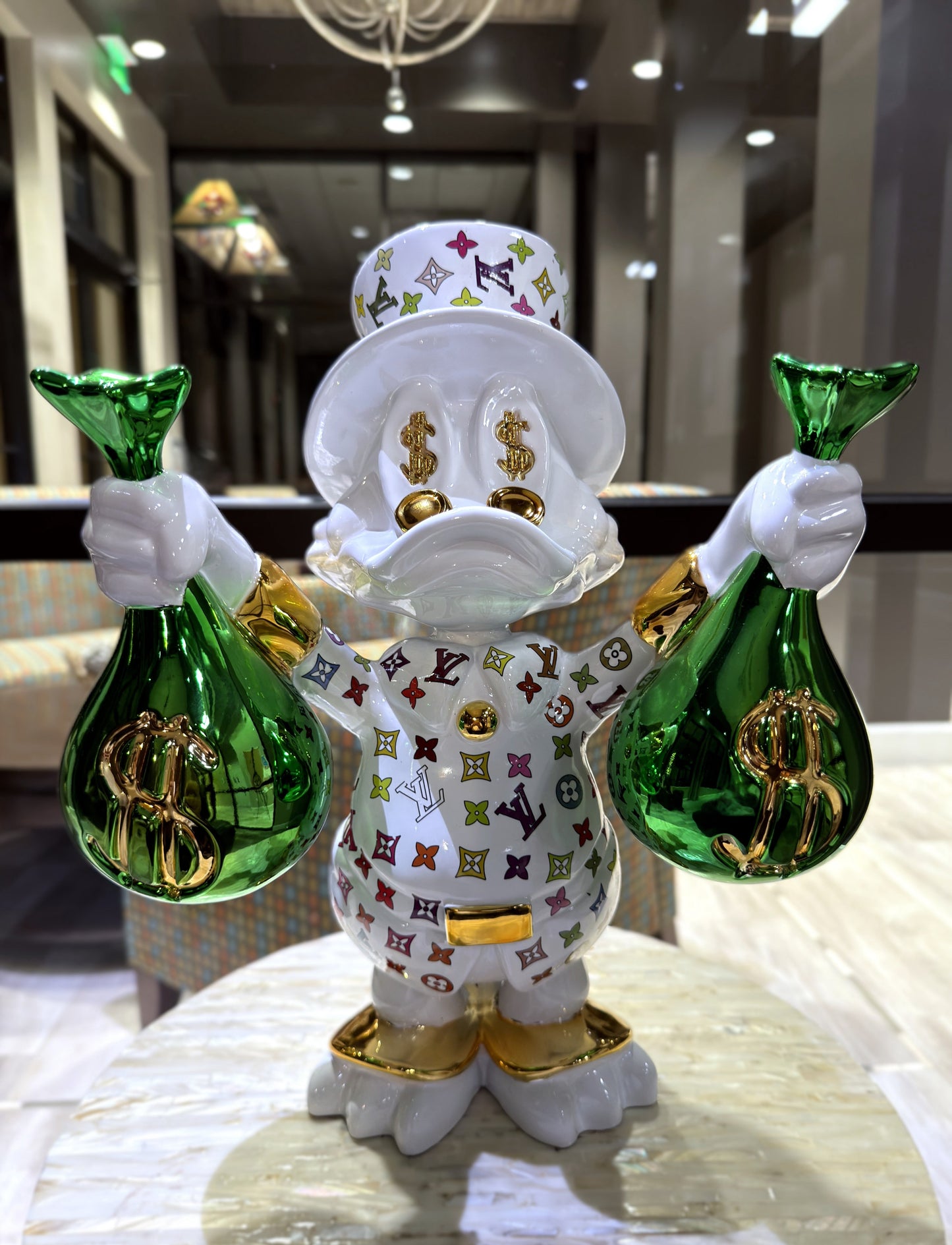 white and gold duck holding two green money bags